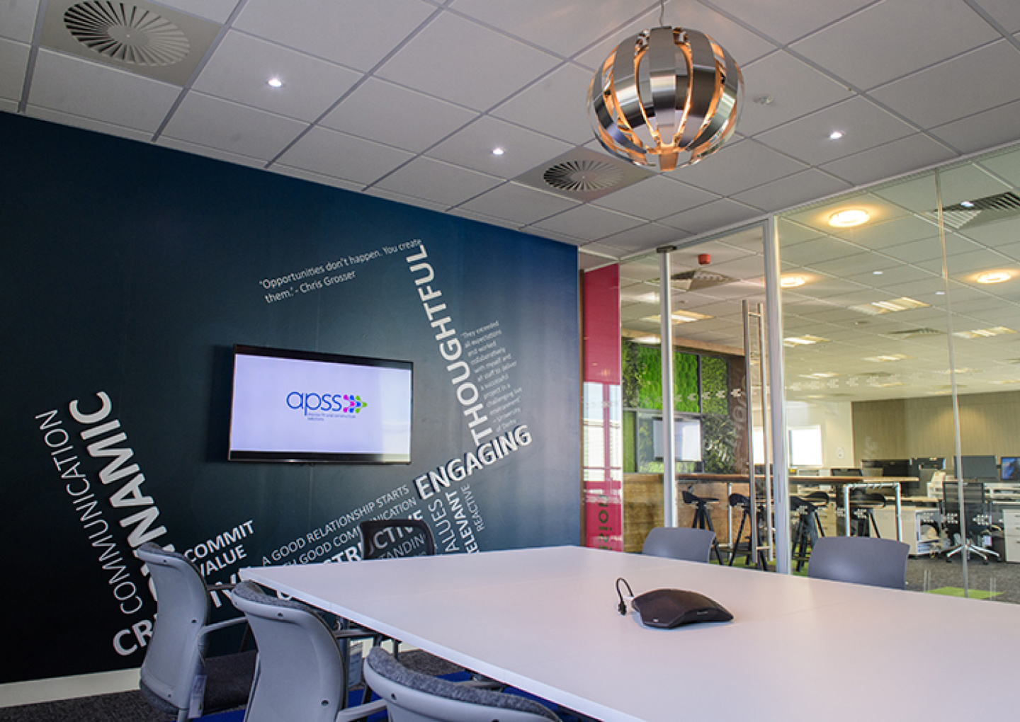Meeting room with inspirational word wall and glass partitions allowing natural light in.