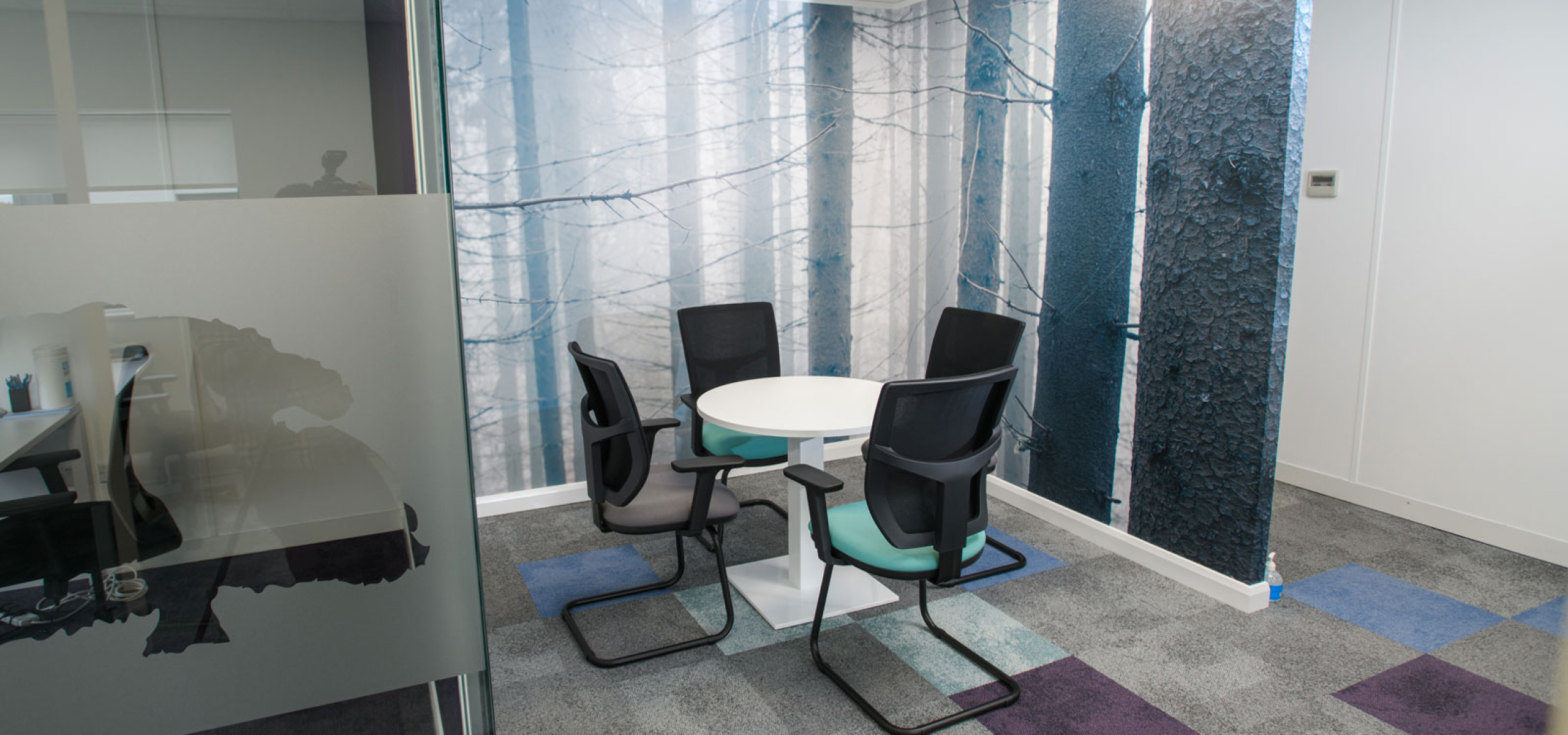 Charnwood-Accountants-meeting-area-huddle-desk-with-floor-to-ceiling-graphics-nature-trees-by-APSS